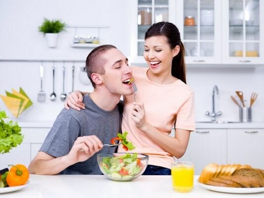 Flickan matar sin man med produkter för att öka styrkan