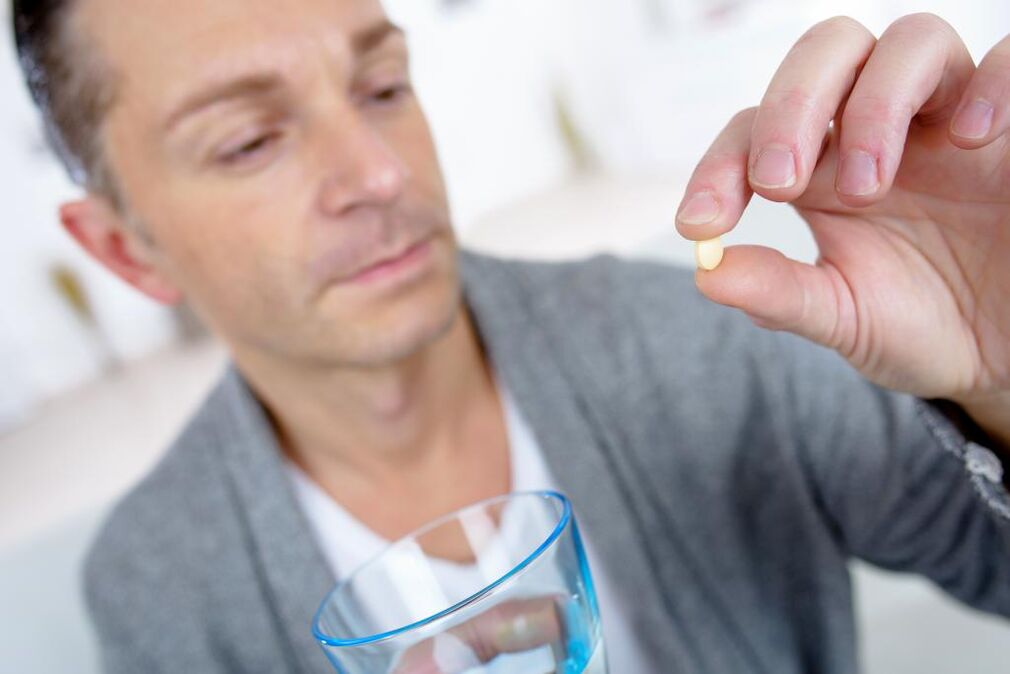 en man dricker ett piller för att öka styrkan